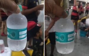Torcedor mostrando uma garrafinha de água mineral