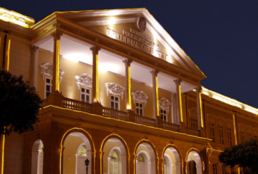 Prédio histórico amarelo com diversas luzes ao redor