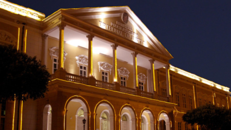 Prédio histórico amarelo com diversas luzes ao redor