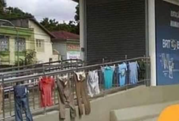 Roupas estendidas em um parapeito metálico em uma rua
