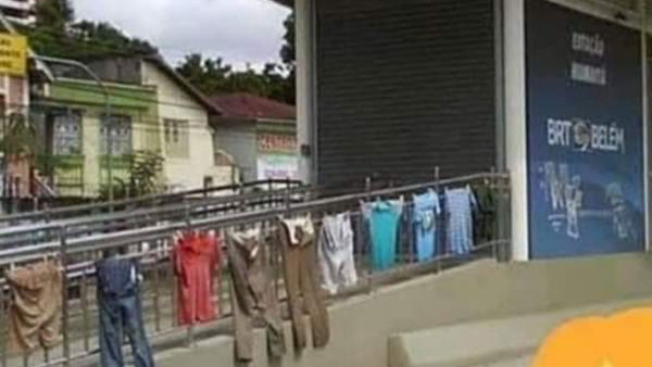 Roupas estendidas em um parapeito metálico em uma rua