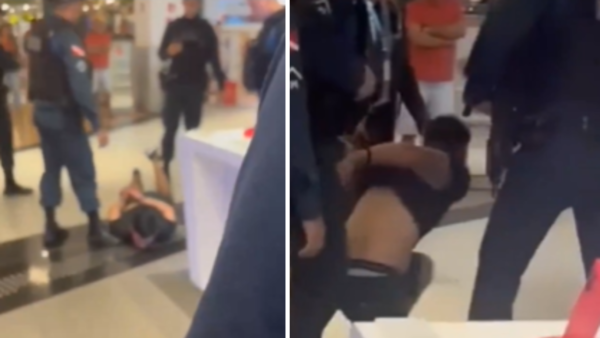 Homem sem camisa sendo levado por policiais militares de dentro de um shopping
