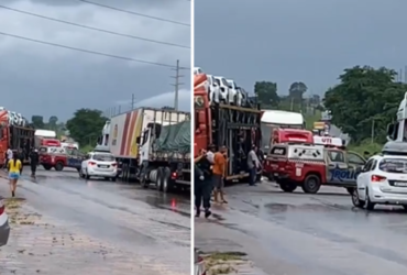 Rodovia com pista molhada cheia de veículos e viaturas da Polícia Militar