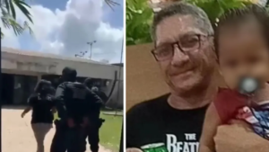 Homem de camisa preta segurando uma criança de colo