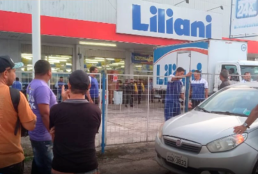 Pessoas aglomeradas em frente a uma loja