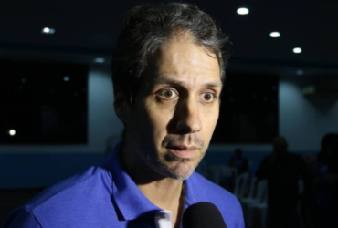 Homem de blusa azul dando entrevista