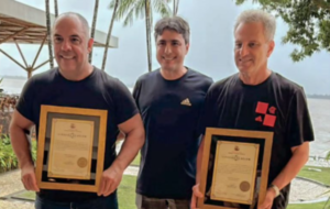 Três homens brancos segurando um quadro