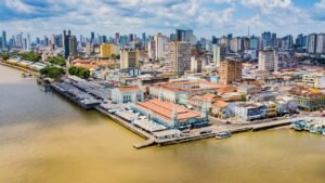 Cidade de Belém vista de cima. Vários prédio e um vasto rio