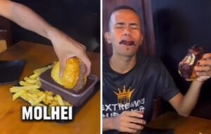 Home comendo hamburguer mistura do açaí, bebida de cor escura típica do Pará