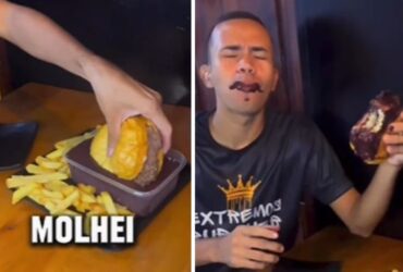 Home comendo hamburguer mistura do açaí, bebida de cor escura típica do Pará