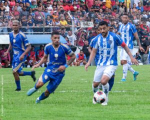 Jogador do Paysandu, de azul e branco conduzindo a bola