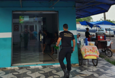 Policial Federal de costa entrando em um estabelecimento