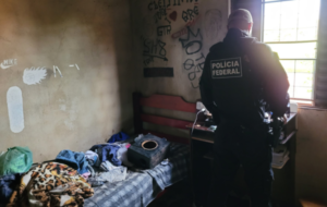 Policial Federal de costas em um quarto