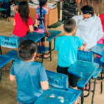 Crianças de costas em uma sala de aula