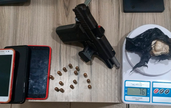 Drogas, celulares, uma arma e 14 munições em uma mesa