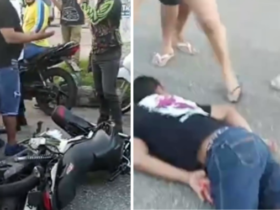 Homem de bruços no chão após um acidente de moto