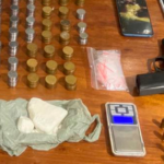Armas, drogas e celulares em cima de uma mesa, todos apreendidos pela polícia