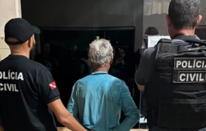 Idosos de costas, sendo apresentado em uma delegacia de polícia
