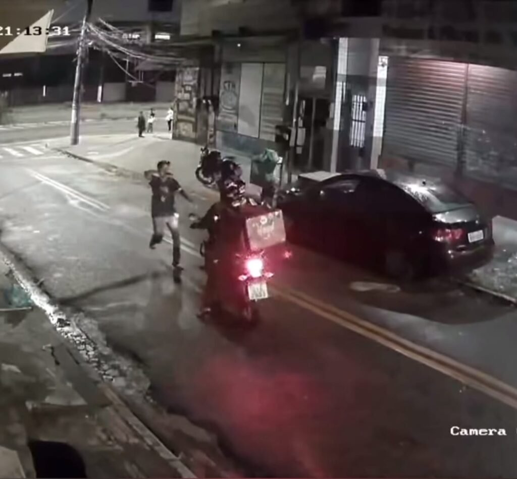 Via escura com um carro ao lado de uma moto