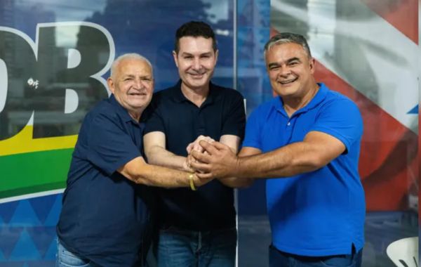 Três políticos de mãos dadas em uma foto