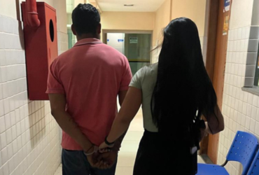 Homem de blusa rosa sendo preso