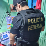 Policial Federal investigando um computador.