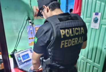 Policial Federal investigando um computador.