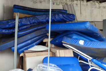 Vários colchões de leitos sujos e empilhados em local inapropriado