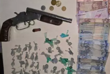 Arma caseira, dinheiro e papelotes de drogas
