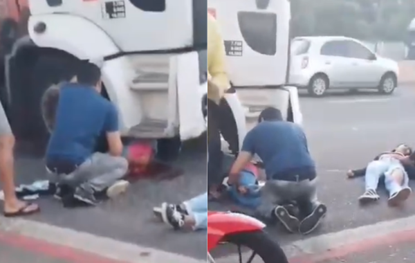 Homem fazendo os primeiros socorros em um vítima que foi arrastada por um caminhão.