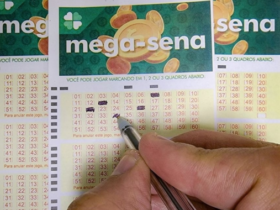 Pessoa marcando números em uma cartela da Mega-Sena