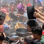 Palestinos disputam pequenas porções de comida em Gaza, devastada pela guerra e pelo bloqueio israelense.