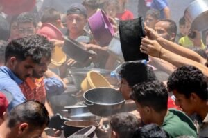 Palestinos disputam pequenas porções de comida em Gaza, devastada pela guerra e pelo bloqueio israelense.