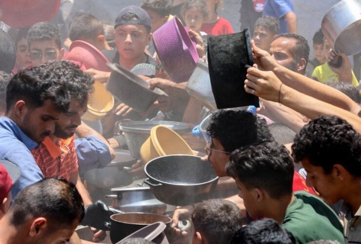 Palestinos disputam pequenas porções de comida em Gaza, devastada pela guerra e pelo bloqueio israelense.