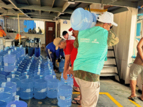 Servidores do Governo do Estado do Amapá organizam e transportam galões de água potável em embarcação destinada ao abastecimento de comunidades atingidas pela salinização das águas na foz do Rio Amazonas.