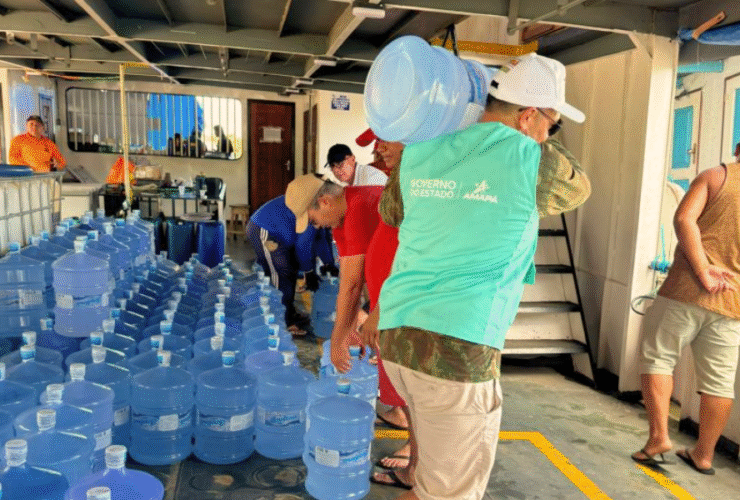 Servidores do Governo do Estado do Amapá organizam e transportam galões de água potável em embarcação destinada ao abastecimento de comunidades atingidas pela salinização das águas na foz do Rio Amazonas.