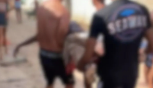 A imagem borrada mostra dois homens carregando o corpo do adolescente morto devido ao ataque