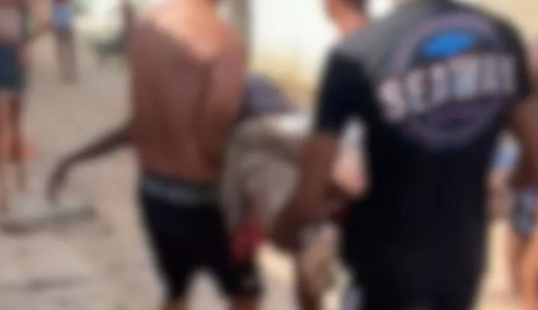 A imagem borrada mostra dois homens carregando o corpo do adolescente morto devido ao ataque