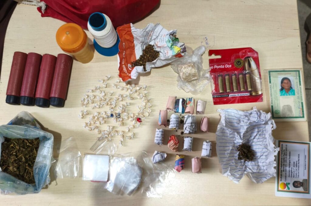 Material apreendido no local do crime. Mesa com drigas, munições, entre outras coisas