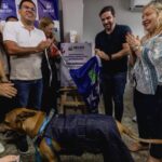 Prefeito Igor Normando tira pano da placa de inauguração do novo hospital veterinário. Na foto, estão outras pessoas e um cachorro
