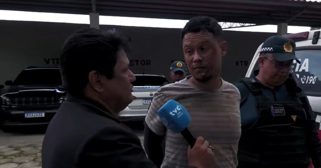 suspeito dando entrevista ao repórter, na companhia do policial militar