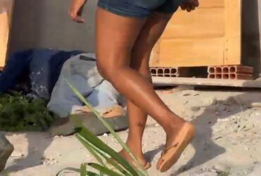 Homem caído ao chão depois de levar tiros. Mulher em pé olhando ele caído