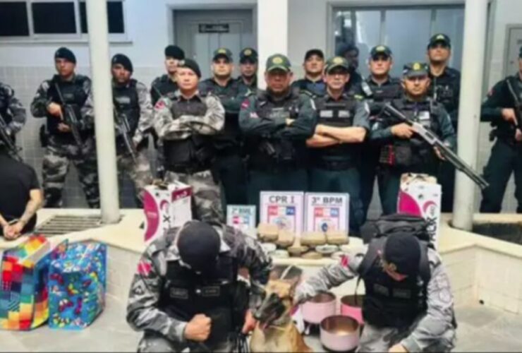 Policiais militares em pose para fotografar maconha apreendida