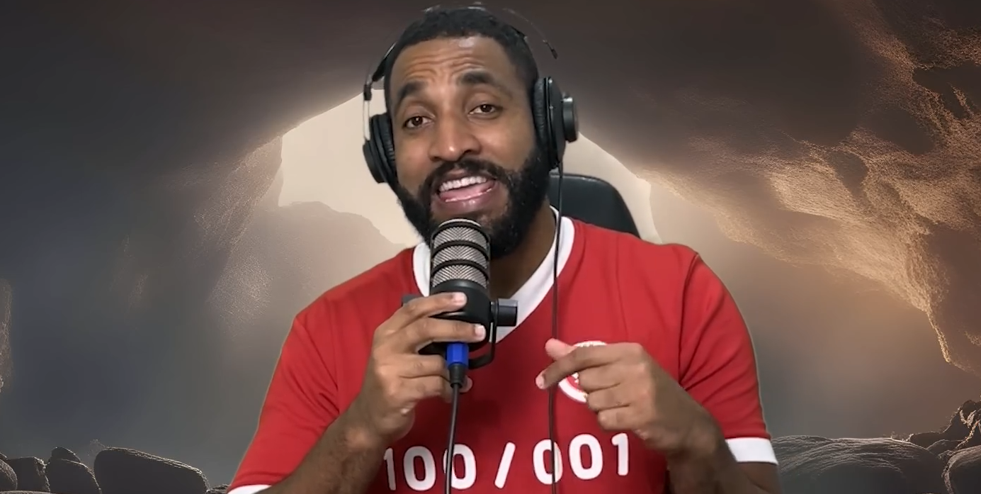 Humorista em vídeo para canal no YouTube usando fones de ouvido e segurando microfone, diante de cenário com fundo artificial que imita o céu.