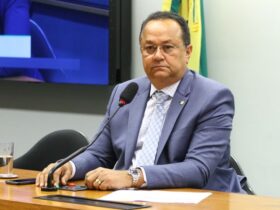 Na imagem, o deputado Silas Câmara sentado com os brços apoiados em um mesa durante uma sessão na câmara