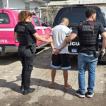 homem detido por dois policiais