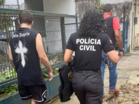 Imagem do suspeito sendo conduzido por agentes da Polícia Civil até a delegacia.