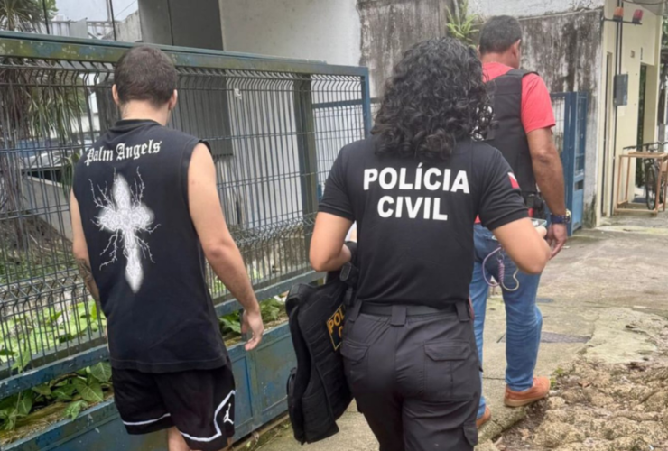 Imagem do suspeito sendo conduzido por agentes da Polícia Civil até a delegacia.