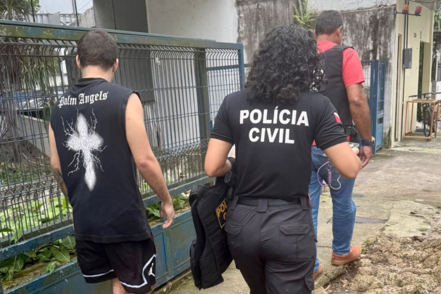 Imagem do suspeito sendo conduzido por agentes da Polícia Civil até a delegacia.