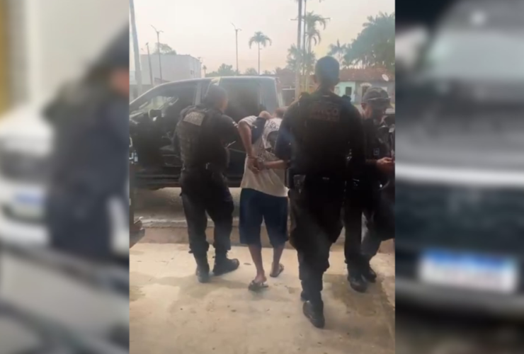 Imagem do suspeito sendo conduzido até a delegacia pelos agentes da polícia civil.
